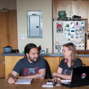 Tabby Rose and Jeff Rose work at the table while roommate Jo Daly plays video games in their shared Toronto condo. (Photograph by Nick Iwanyshyn)