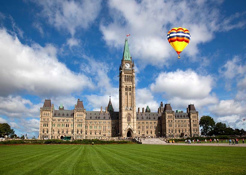 A hot air balloon in the distance ofof Parliament Hill in Ottawa. (Shutterstock)