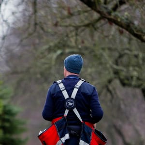 A Canada Post letter carrier delivers mail by foot to houses in Vancouver, B.C. (Ben Nelms/Getty)