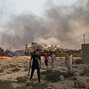 31/08/2016 -- Qayarah, Iraq -- 

Men inspect burning oil wells on the outskirts of Qayyarah.