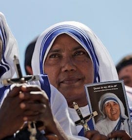 A Missionaries of Charity nun holds a photo of Mother Teresa in St. Peter's Square at the Vatican during a jubilee audience for workers and volunteers of mercy led by Pope Francis, Saturday, Sept. 3, 2016. The square hosts a ceremony Sunday expected to draw hundreds of thousands of admirers of Mother Teresa, a nun who before her death in 1997, cared for the destitute who were dying in the streets of India. (AP Photo/Alessandra Tarantino)