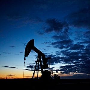 An oil and gas pumpjack is silhouetted against a sunset tinged sky near Carstairs, Alta., Wednesday, May 30, 2012. (Jeff McIntosh/CP)