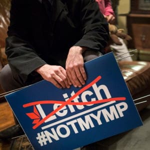 Mark Ruzylo holds a #NotMyMP sign in a neighbours home. (Photograph by Nick Iwanyshyn)