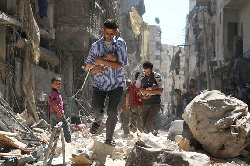 Syrian men carrying babies make their way through the rubble of destroyed buildings following a reported air strike on the rebel-held Salihin neighbourhood of the northern city of Aleppo, on September 11, 2016. Air strikes have killed dozens in rebel-held parts of Syria as the opposition considers whether to join a US-Russia truce deal due to take effect on September 12. (Ameer Alhalbi/AFP/Getty Images)