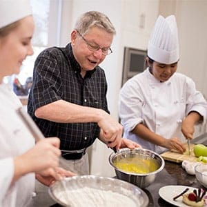 Amica at Oakville resident Norm Graham works on a recipe with students Jennifer Lindeman (left) and Nicole Ates. (Photograph by Nick Iwanyshyn)
