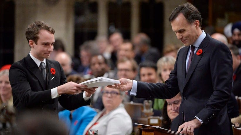 Finance Minister Bill Morneau gives a copy of the government's fall economic update to a page in the House of Commons on Parliament Hill in Ottawa on Tuesday, November 1, 2016. THE CANADIAN PRESS/Adrian Wyld