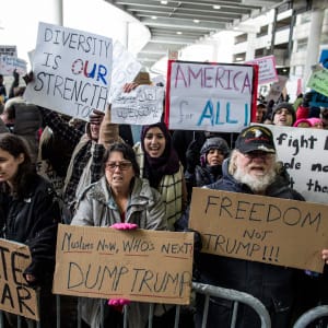 Demonstrators hold signs and chant during a protest against President Donald Trump's executive order banning travel to the United States by citizens of several countries Sunday, Jan. 29, 2017, at Detroit Metropolitan Airport. (Jeffrey M. Smith/AP/CP)