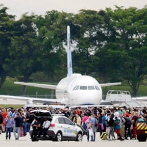 People stand on the tarmac at the Fort Lauderdale-Hollywood International Airport after a shooter opened fire inside a terminal of the airport, killing several people and wounding others before being taken into custody, Friday, Jan. 6, 2017, in Fort Lauderdale, Fla. (Lynne Sladky/AP/CP)