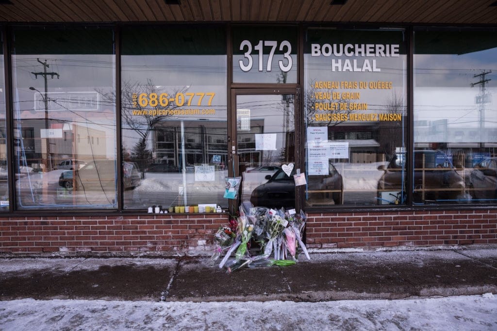 Flowers and messages of peace and condolences amassed outside the butcher shop of Azzedine Soufiane, a 57 year old moroccan who was killed in the attack. The name of his shop is Boucherie Assalam (peace in arabic). It is in Ste-Foy about a short distacne from the mosque. (Photograph by Roger LeMoyne)