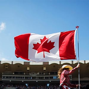 A Calgary Stampede rodeo girl carries the Canadian flag. (Todd Korol/Reuters)
