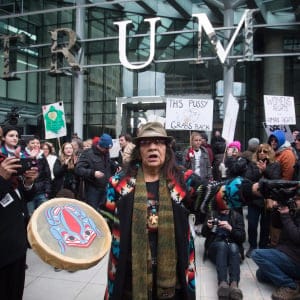 Viviane Sandy, of Williams Lake, B.C., plays a drum outside the official opening of the Trump International Hotel and Tower in Vancouver, B.C., on Tuesday February 28, 2017. U.S. President Donald Trump's sons Donald Jr. and Eric attended the opening. (Darryl Dyck/CP)