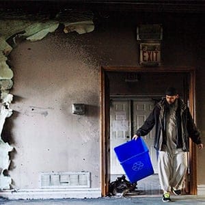 Imam Shazim Khan cleans up debris, on Sunday, November 15, 2015, after the only mosque in Peterborough, Ont., was deliberately set alight Saturday night. (THE CANADIAN PRESS/Christopher Katsarov)