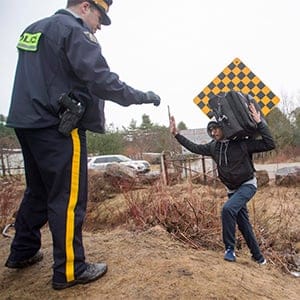 An RCMP officer warns a man to cross at the legal border crossing or he will be arrested at the border from New York into Canada on Wednesday, March 8, 2017 in Hemmingford, Quebec. (THE CANADIAN PRESS/Ryan Remiorz)