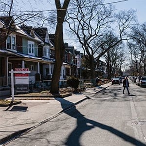 A pedestrian walks between homes for sale in the Leslieville neighborhood of Toronto, Ontario, Canada, on Saturday, March 4, 2017. In Toronto prospective buyers have found themselves in bidding wars, due in part to the largest price surge in almost 30 years and coupled with an ever tightening inventory supply. (Mark Sommerfeld/Bloomberg/Getty Images)