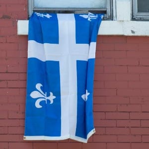 A Quebec flag hangs out a window during the annual Saint Jean Baptiste Day parade in Montreal. (Graham Hughes/CP)