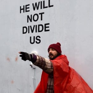 US actor Shia LaBeouf(L) during his He Will Not Divide Us livestream outside the Museum of the Moving Image in Astoria, in the Queens borough of New York January 24, 2017 as a protest against President Donald Trump.  
LaBeouf has installed a camera at the Museum of the Moving Image in New York that will run a continuous live stream for the duration of Trumps presidency. LaBeouf is inviting the public to participate in the project by saying the phrase, He will not divide us, into the camera. (Timothy A. Clary/AFP/Getty Images))