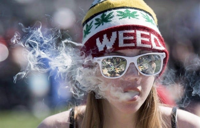 A woman exhales while smoking a joint during the annual 420 marijuana rally on Parliament hill on Wednesday, April 20, 2016 in Ottawa. Some teens say their likelihood of using weed hasn't changed since the Liberal government announced details of its legalization plan - though they say it's made them more aware of information on both sides of the debate.THE CANADIAN PRESS/Justin Tang