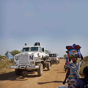 In this Monday, Dec. 30, 2013 file photo, a United Nations armored vehicle passes displaced people walking towards the U.N. camp in Malakal, South Sudan. An independent investigation released Tuesday, Nov. 1, 2016, of attacks in July on a U.N. compound in South Sudan housing 27,000 displaced people, and a private compound not far away housing U.N. staff and aid workers, is sharply critical of the U.N. peacekeeping mission's leadership and the response by troops from China, Ethiopia, Nepal and India. (Ben Curtis/AP/CP)