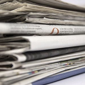 Stacked newspapers close up. (Stefan Wolny/Shutterstock)