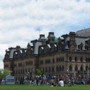 People relax on the front lawn of the Parliament buildings near Langevin Block in Ottawa, Wednesday June 21, 2017. The federal government is renaming the Langevin Block building, which sits across from Parliament Hill, out of respect for Indigenous Peoples. (Adrian Wyld/CP)
