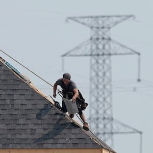A construction worker shingles the roof of a new home in a development in Ottawa on Monday, July 6, 2015. Experts say measures introduced by the Ontario government to cool the red-hot housing market are likely to leave a lot of the buyers on the sidelines as they await to see the impact of the changes. THE CANADIAN PRESS/Sean Kilpatrick