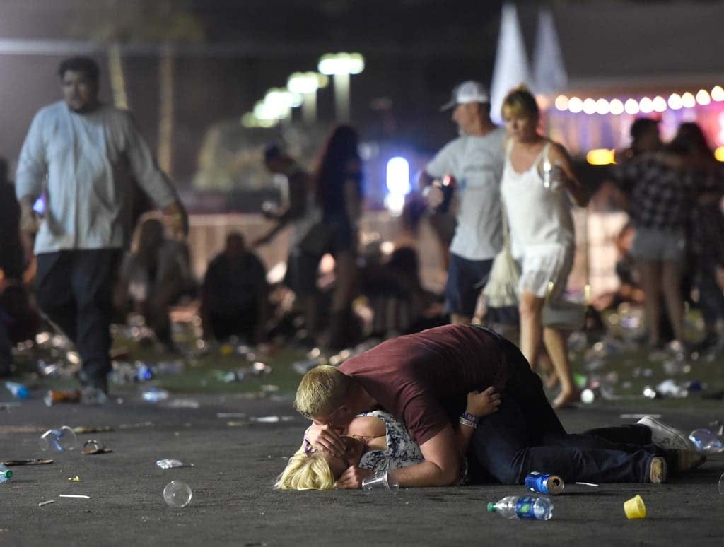 People lie on the ground at the Route 91 Harvest country music festival after apparent gun fire was hear on October 1, 2017 in Las Vegas, Nevada. There are reports of an active shooter around the Mandalay Bay Resort and Casino.  (David Becker/Getty Images)