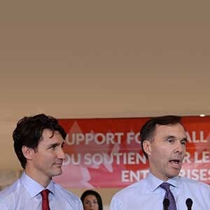 Finance Minister Bill Morneau speaks to members of the media as Prime Minister Justin Trudeau looks on at a press conference on tax reforms in Stouffville, Ont., on Monday, October 16, 2017. THE CANADIAN PRESS/Nathan Denette