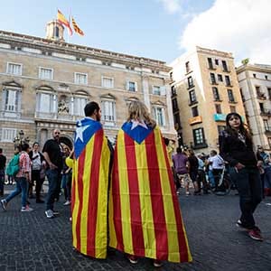 BARCELONA, SPAIN - OCTOBER 28: Two people wrapped in the Catalan independence flag gather outside the Catalan Government building, the Palau de la Generalitat on October 28, 2017 in Barcelona, Spain. The Spanish government stripped Catalonia of its autonomy after the Catalan parliament voted yesterday to declare independence. (Photo by Jack Taylor/Getty Images)