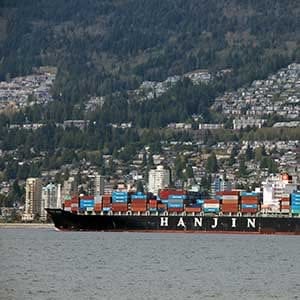 Vancouver, Canada - April 18, 2014: Hanjin cargo vessel leaving Vanouver harbour with various commercial shipping containers on  board