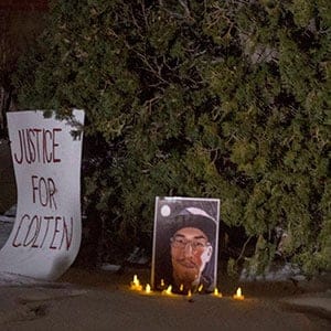 Michelle Stewart, a supporter of the Boushie family, looks at a sign and photo of Colten Boushie in front of the Court of Queen's Bench on the day of closing arguments and first day of jury in deliberation in the trial of Gerald Stanley, the farmer accused of killing the 22-year-old Indigenous man, in Battleford, Sask., Thursday, February 8, 2018. THE CANADIAN PRESS/Liam Richards