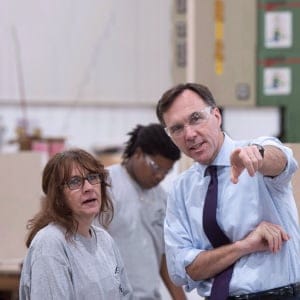 Finance Minister Bill Morneau chats with a worker at a kitchen counter factory, in Montreal on Tuesday, October 17, 2017. (Paul Chiasson/CP)