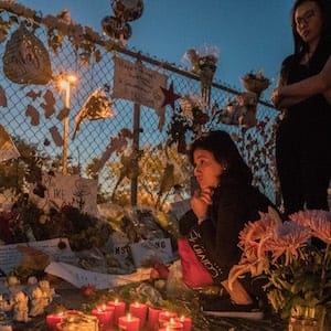 MARJORY STONEMAN DOUGLAS HIGH SCHOOL, PARKLAND, FLORIDA. 02/25/2018
A mourner sits by candles at a memorial tribute outside the school.
On February 14, 2018, a former school  Stoneman Douglas student Nikolas Cruz entered the school at 2.30pm and proceeded to kill 3 teachers and 14 school children in a 7 minute shooting spree. Marjory Stoneman Douglas High School is located in Parkland, Florida, in the Miami metropolitan area. It is a part of the Broward County Public School district, and it is the only public high school in Parkland.  

Photo by Giles Clarke/Getty Images