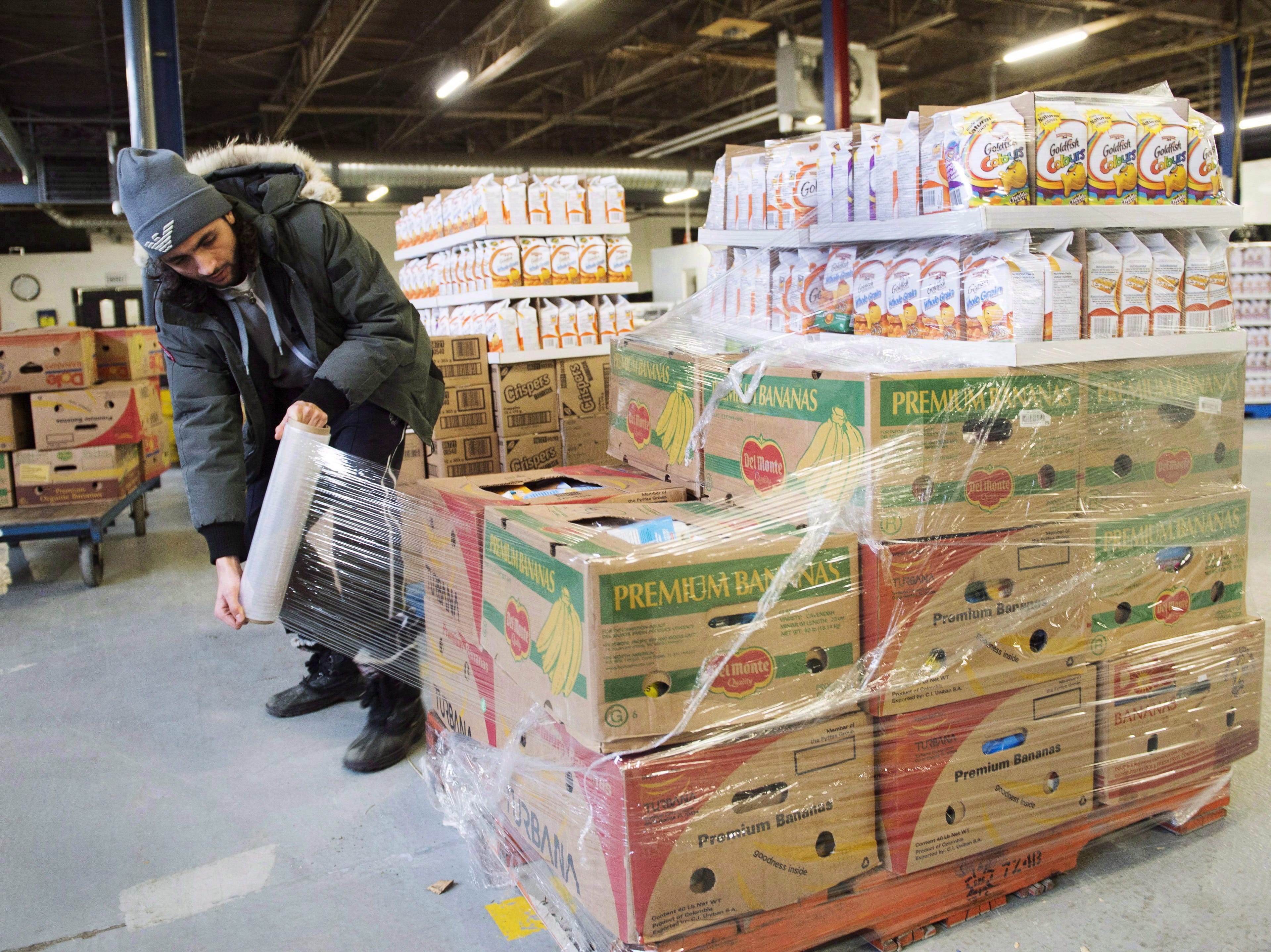 Artem Mousessian wraps a shipment for delivery at the distribution centre for Moisson Montreal, the largest food bank in Canada, Thursday, Jan. 28, 2016 in Montreal. (THE CANADIAN PRESS/Ryan Remiorz)