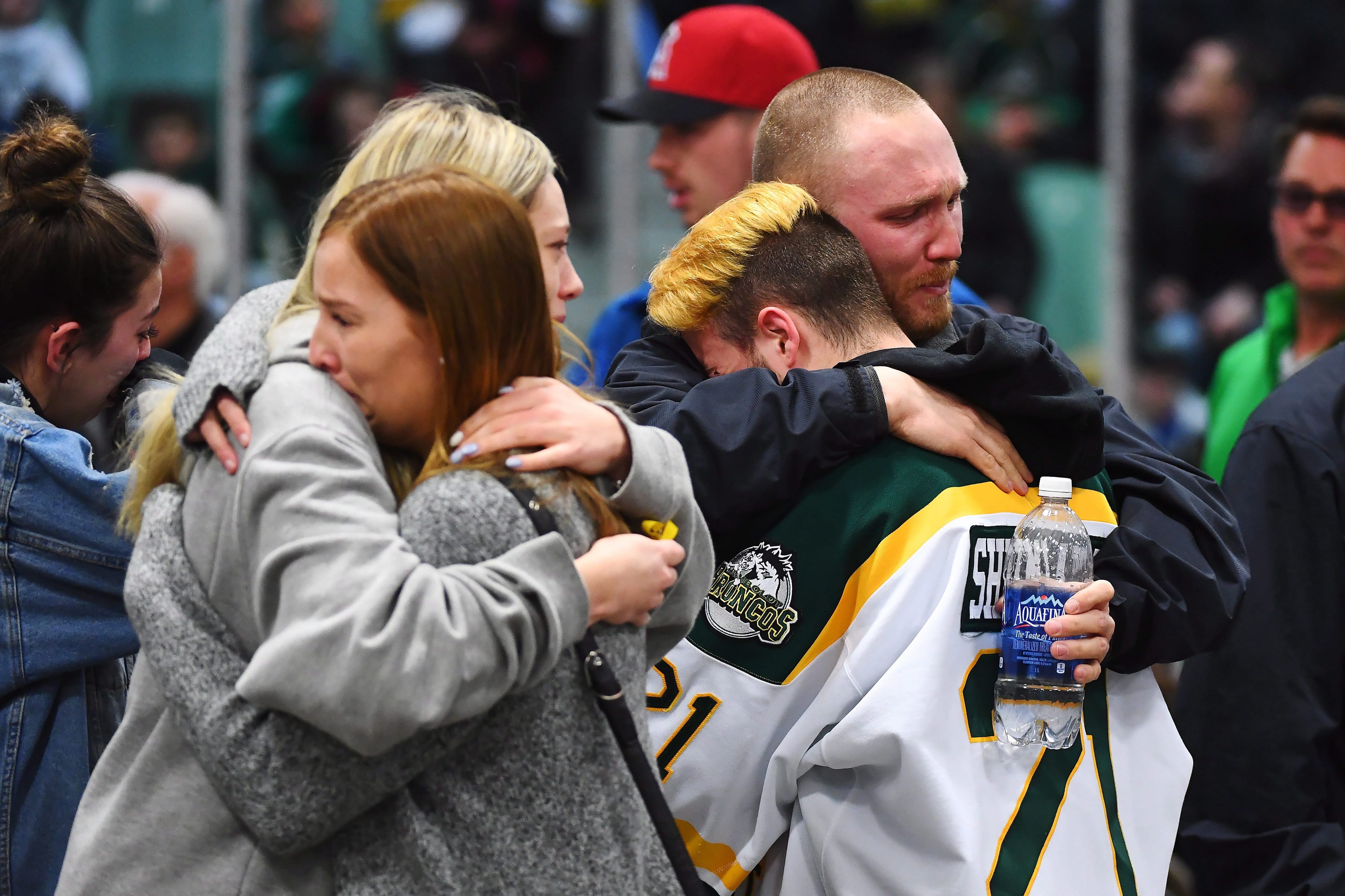 Mourners comfort each other as people attend a vigil at the Elgar Petersen Arena, home of the Humboldt Broncos, to honour the victims of a fatal bus accident in Humboldt, Sask. on Sunday, April 8, 2018. THE CANADIAN PRESS/Jonathan Hayward