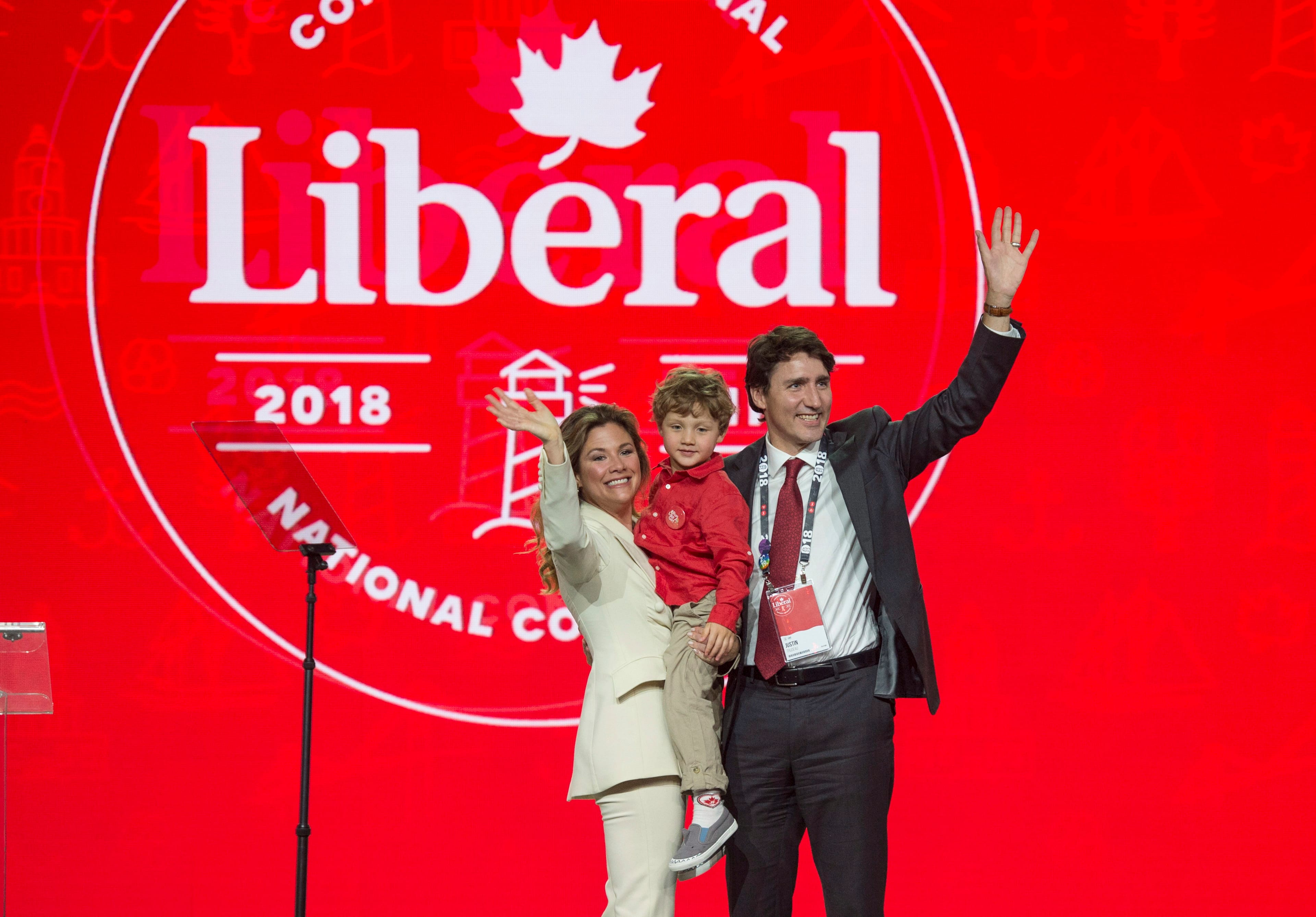 Prime Minister Justin Trudeau, right, and his wife Sophie Gregoire Trudeau, left, wave to supporters with their son Hadrien following her speech at the federal Liberal national convention in Halifax on Friday, April 20, 2018. (THE CANADIAN PRESS/Darren Calabrese)