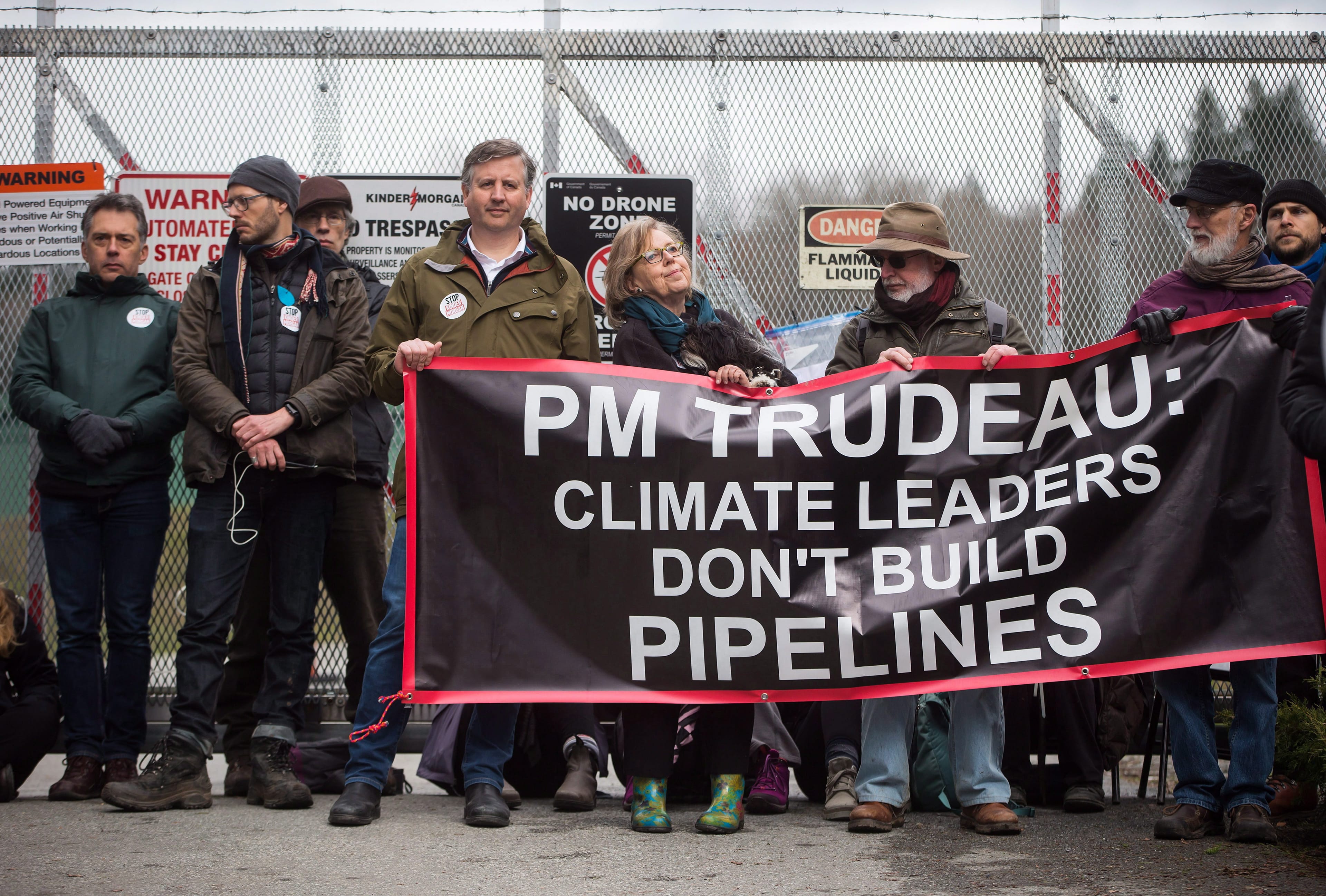 Federal Green Party Leader Elizabeth May 
(centre) and NDP MP Kennedy Stewart (centre, left) stand with protesters before they were arrested outside Kinder Morgan's facility in Burnaby, B.C., on Friday March 23, 2018. (THE CANADIAN PRESS/Darryl Dyck)