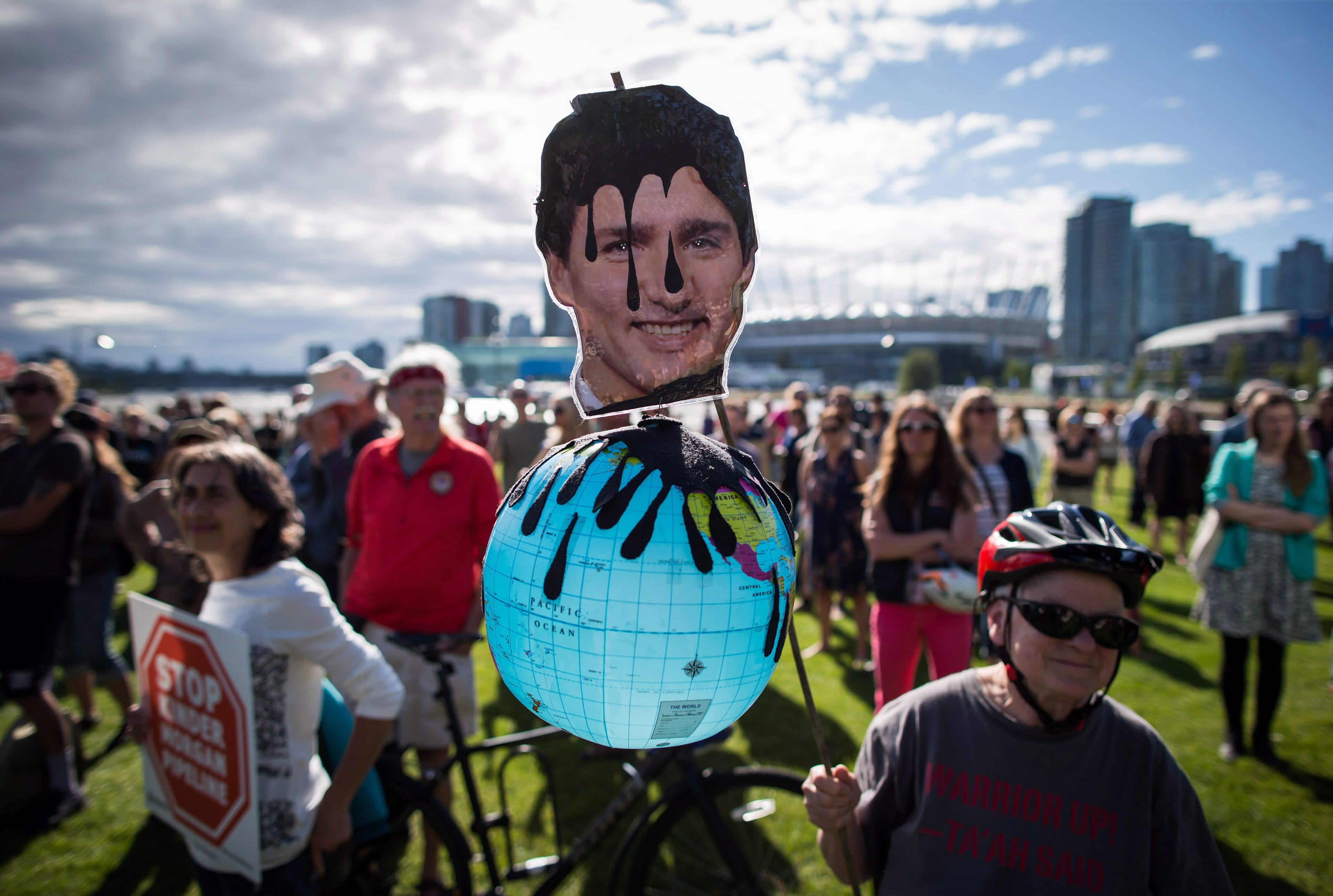 A protester holds a photo of Prime Minister Justin Trudeau covered in oil during a protest against the Kinder Morgan Trans Mountain Pipeline expansion in Vancouver, B.C., on Tuesday May 29, 2018. (THE CANADIAN PRESS/Darryl Dyck)