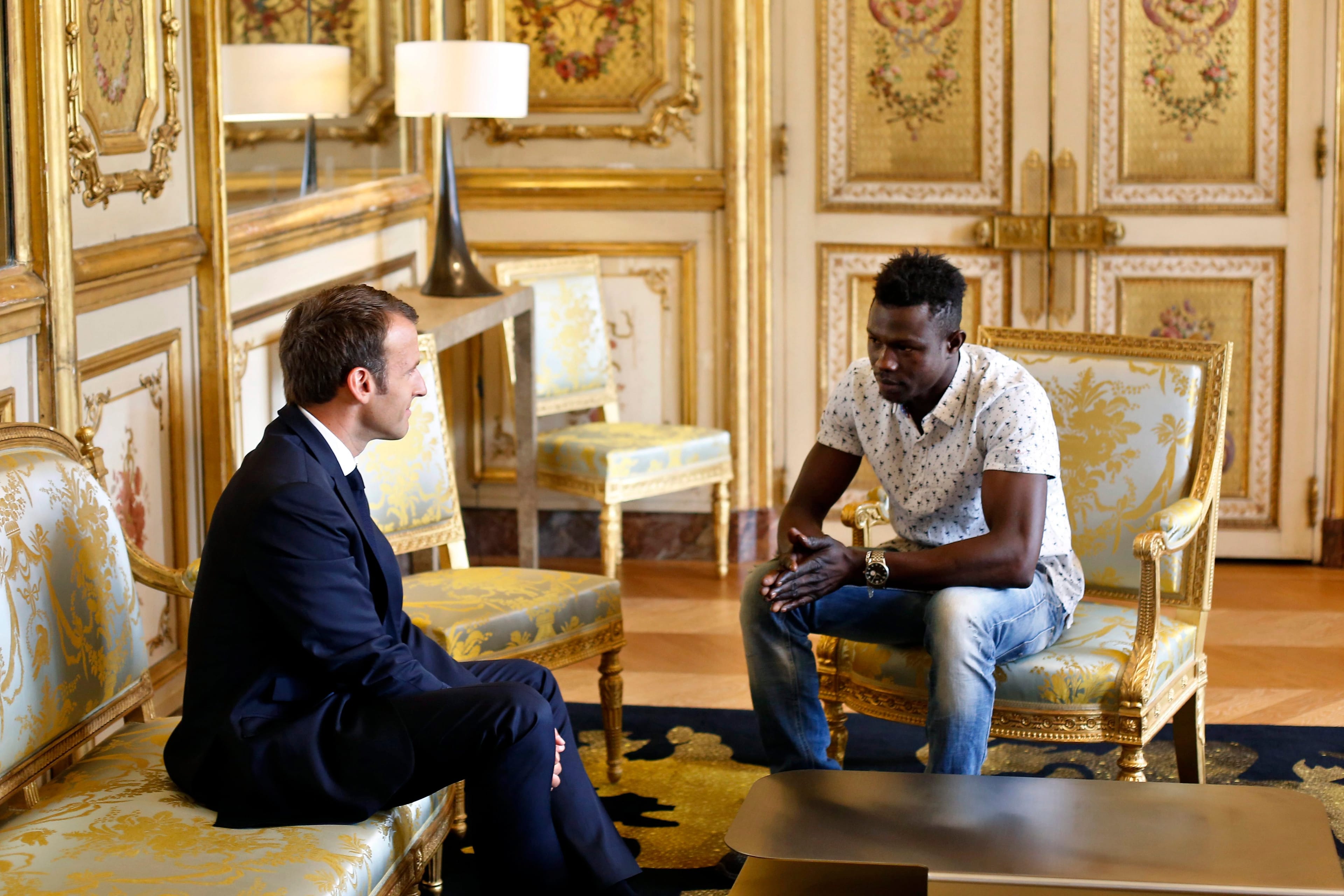 French President Emmanuel Macron meets with Mamoudou Gassama, 22, from Mali, who was living illegally in France who was honored for scaling an apartment building to save a 4-year-old child dangling balcony. (Thibault Camus/AP/CP)