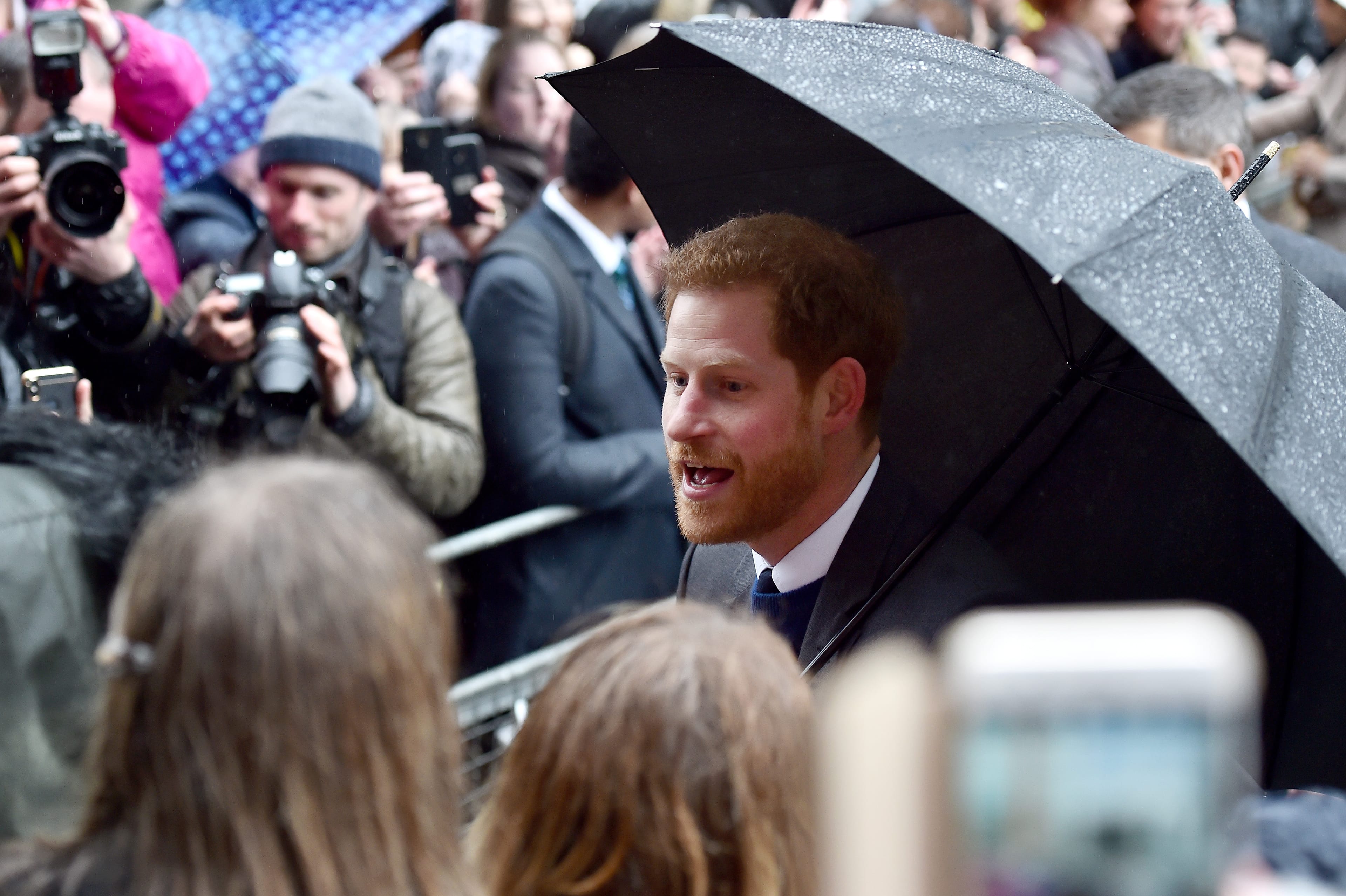 Prince Harry interacts with the crowd as photographers snap photos behind him outside the Crown Liquor Saloon during his visit with Meghan Markle to Northern Ireland on March 23, 2018 in Belfast, Northern Ireland, United Kingdom.  (Charles McQuillan/Getty Images)