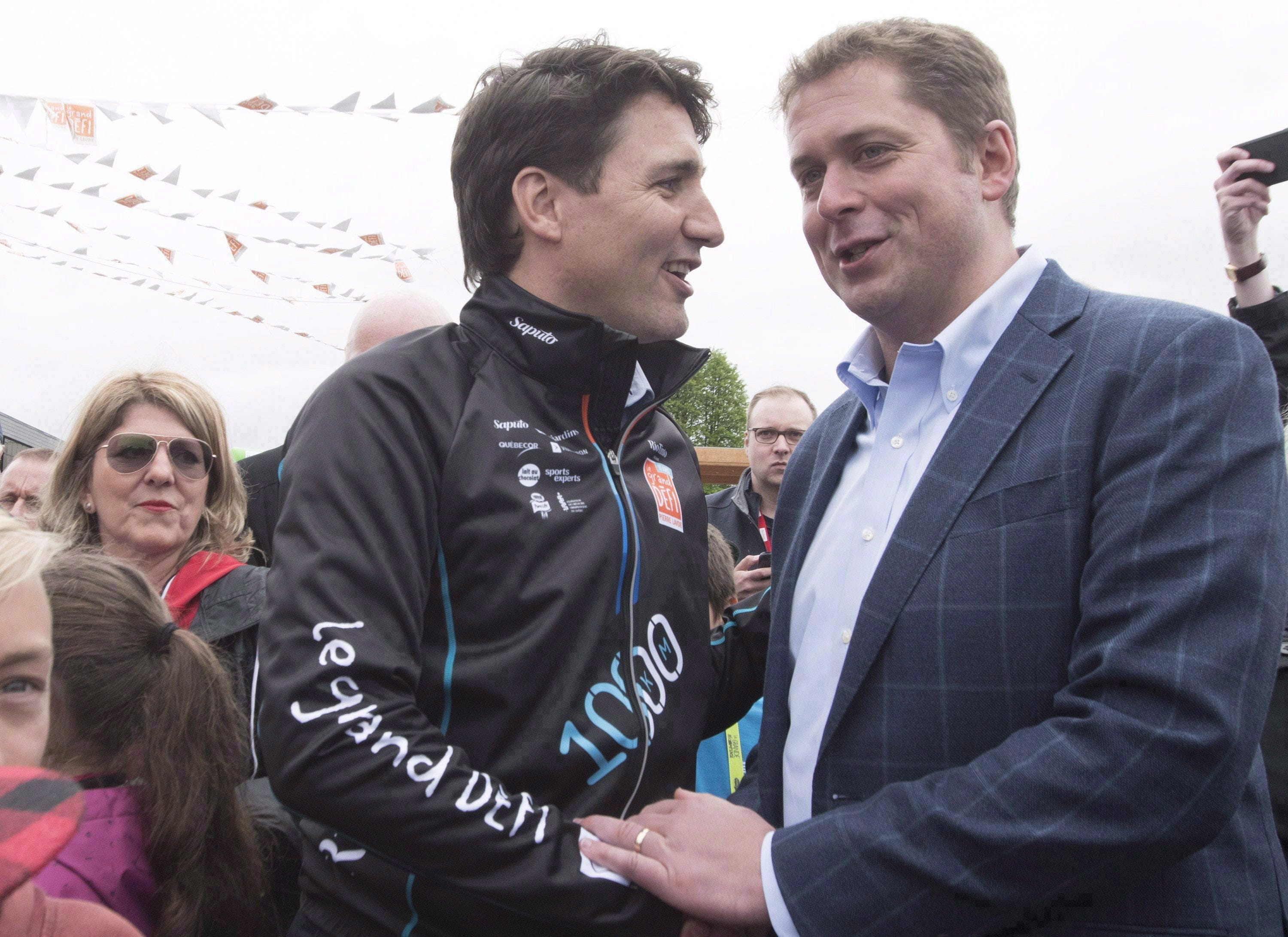 Prime Minister Justin Trudeau, left, shakes hand with Conservative Leader Andrew Scheer at the start of the Defi Pierre Lavoie, a 1,000km bicycle trek, Thursday, June 14, 2018 in Saguenay, Que. (THE CANADIAN PRESS/Jacques Boissinot)