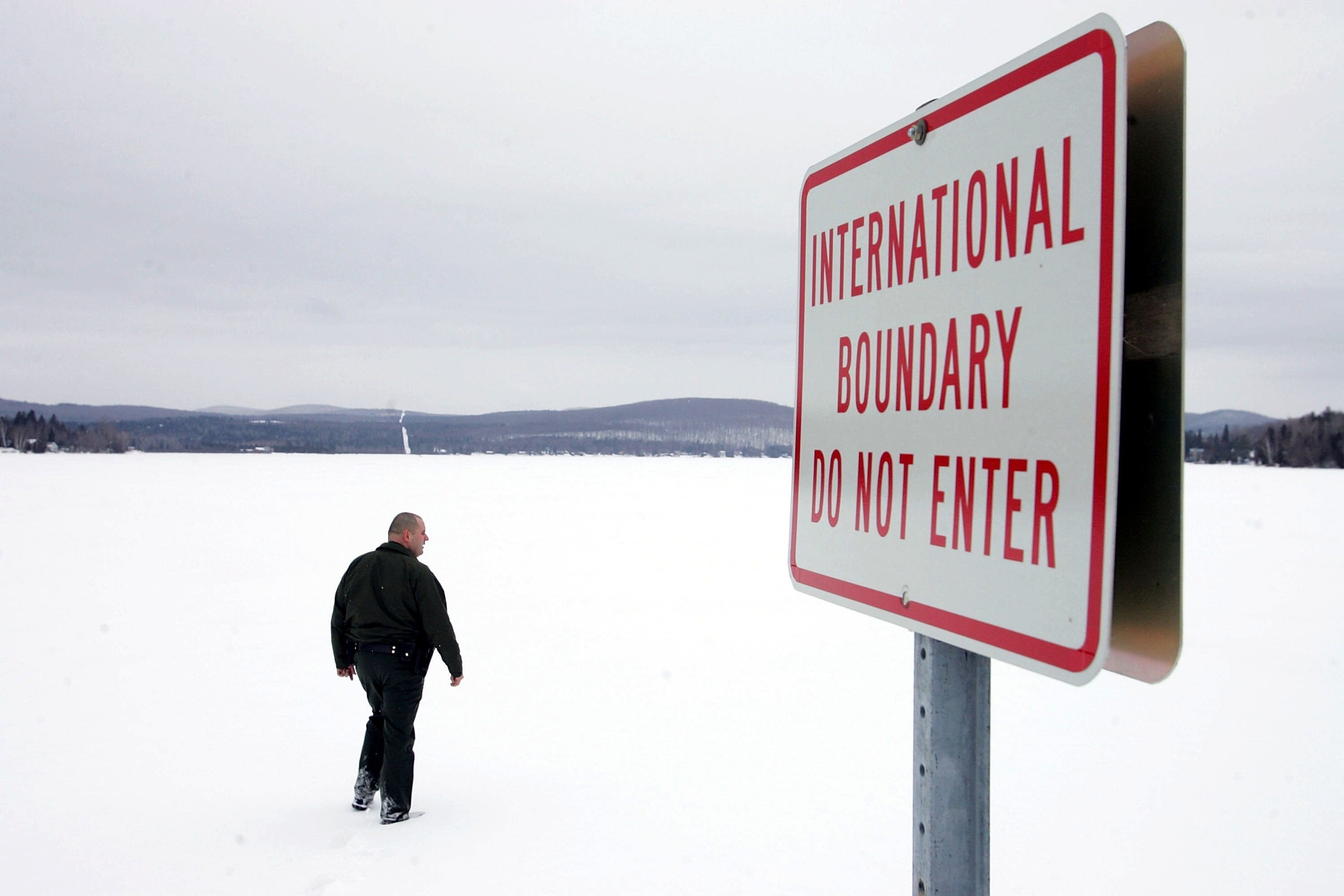 A U.S. Border Patrol Agent walks onto a frozen lake that is split between Canadian territory to the right and the U.S. March 22, 2006 near Norton, Vermont. (Photo by Joe Raedle/Getty Images)