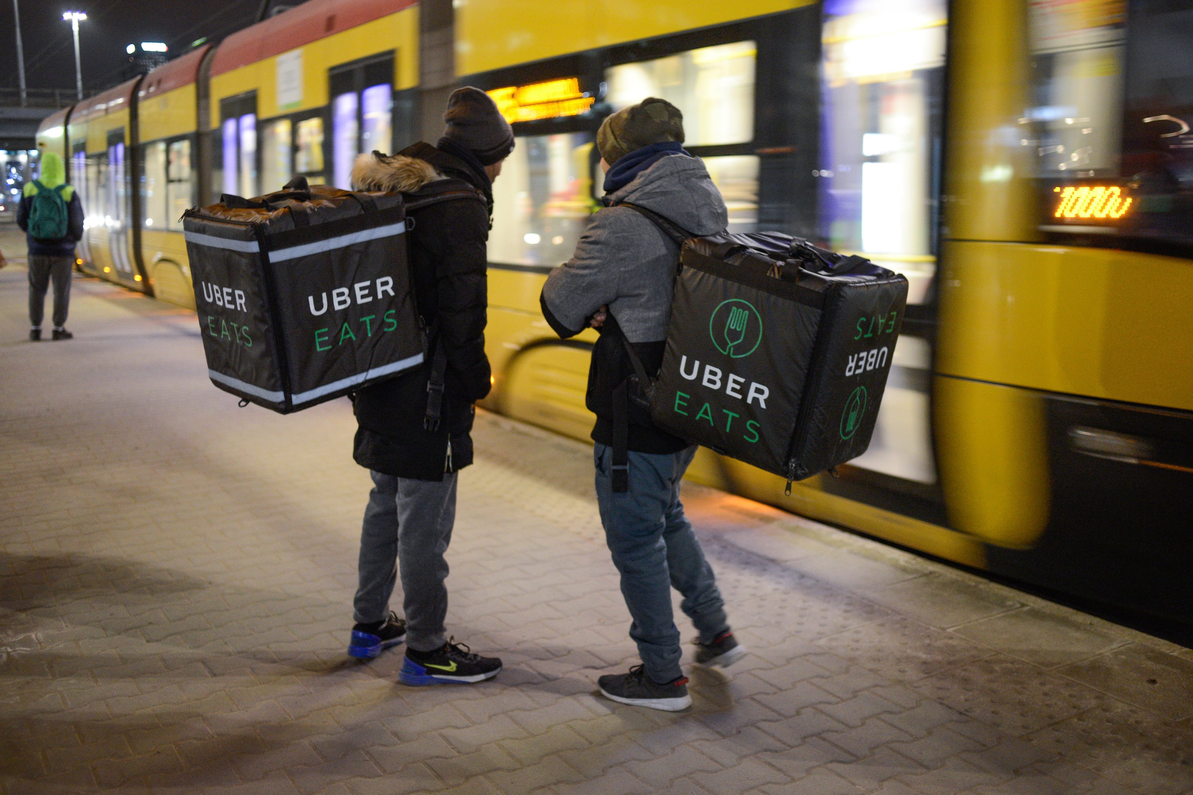 Uber Eats delivery workers are seen waiting for a tram in central Warsaw, Poland on February 27, 2018. (Photo by Jaap Arriens/NurPhoto via Getty Images)