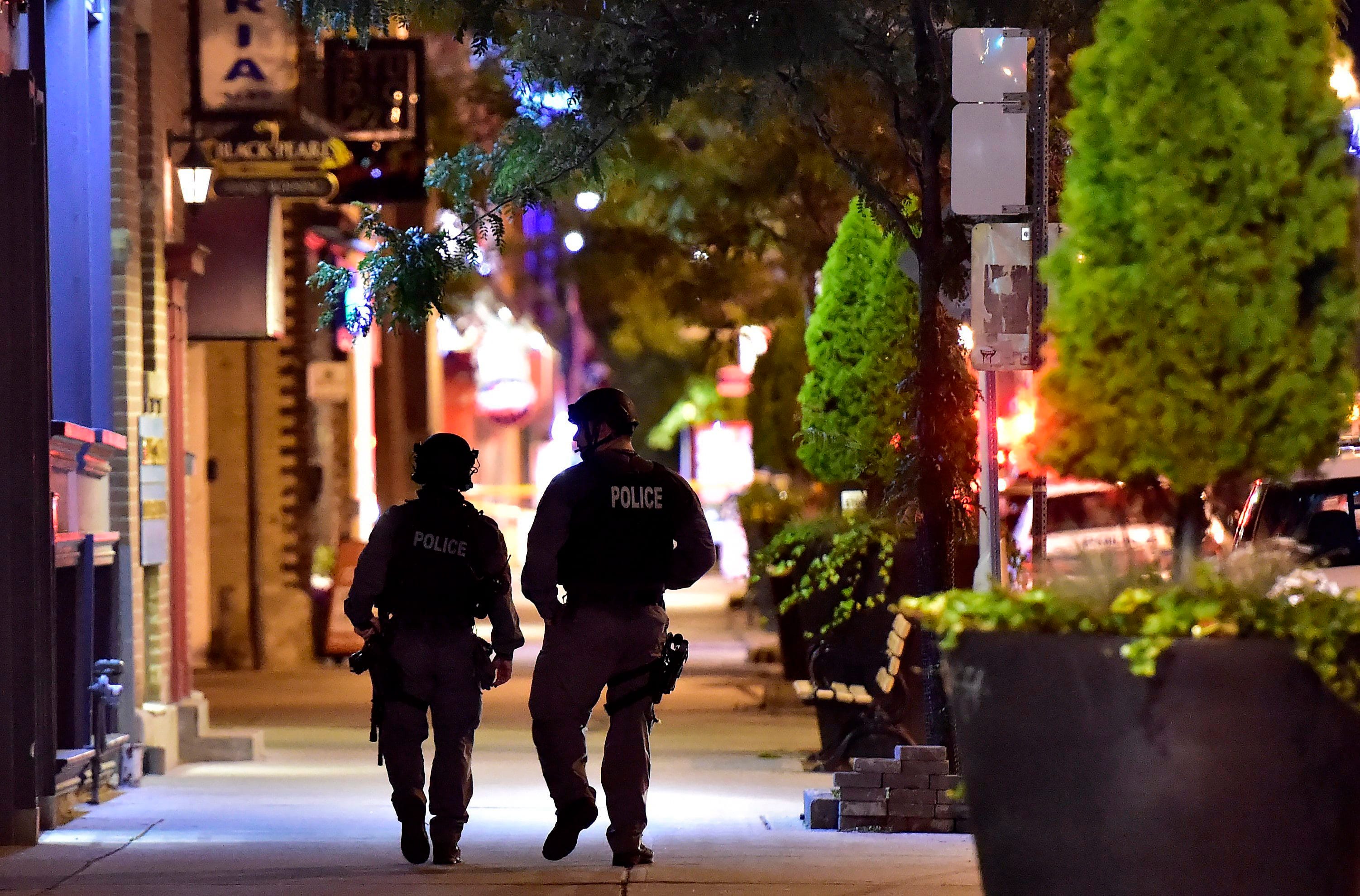 Tactical police officers walk along Danforth Ave. at the scene of a mass casualty incident in Toronto on Monday, July 23, 2018. (THE CANADIAN PRESS/Frank Gunn)