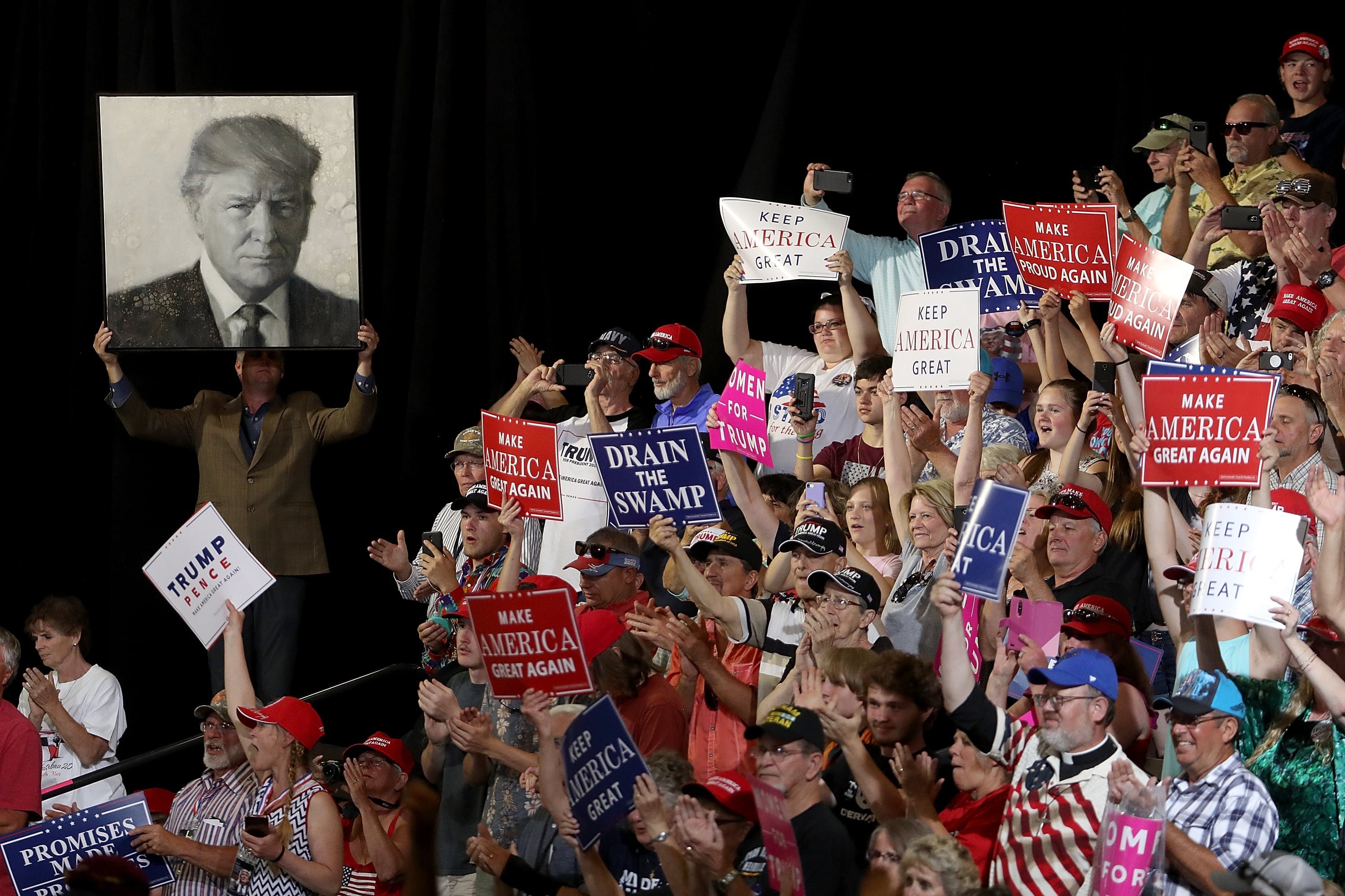 Supporters of U.S. president Donald Trump hold signs during a campaign rally at Four Seasons Arena on July 5, 2018 in Great Falls, Montana. (Justin Sullivan/Getty Images)