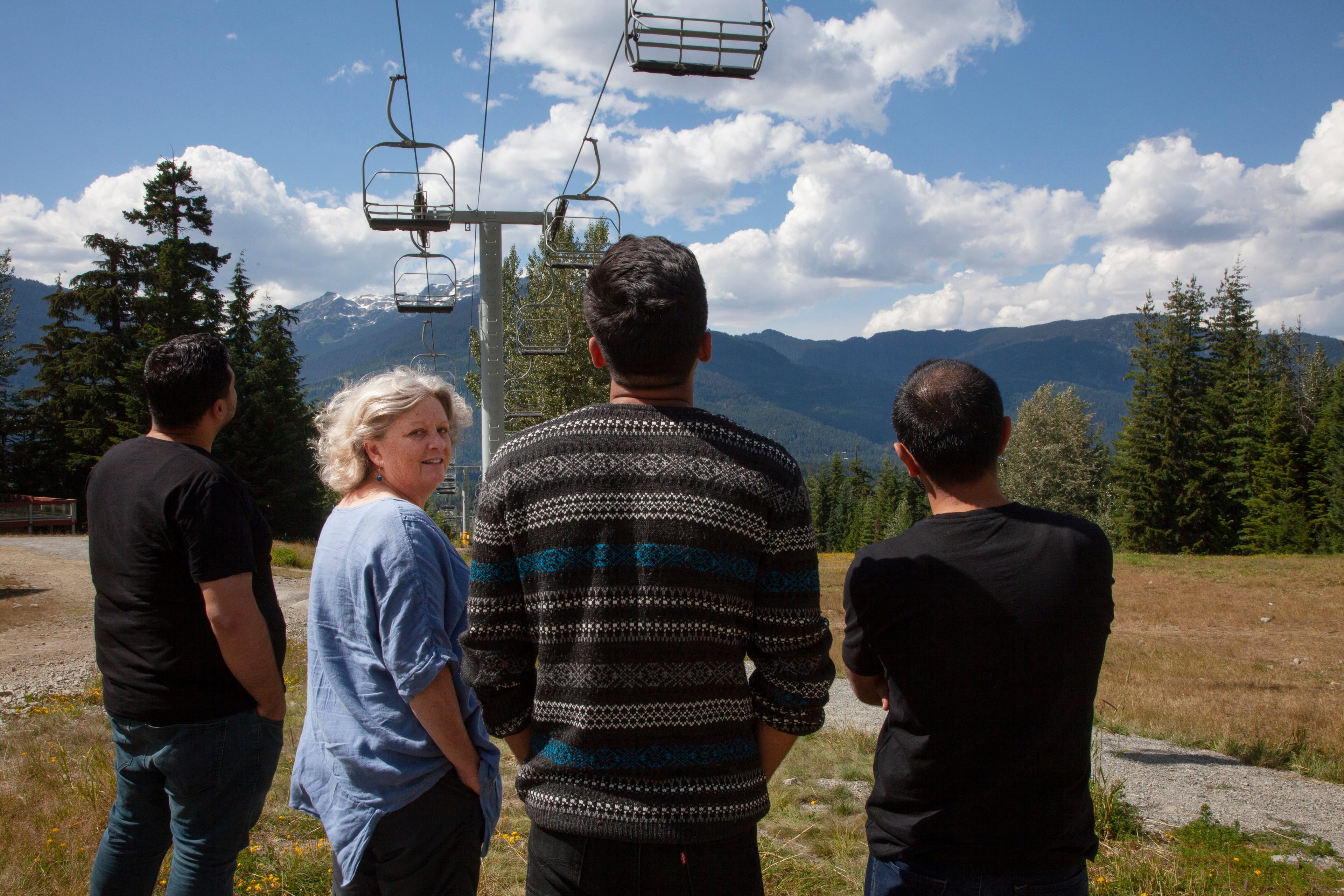This is Laurie Cooper. She lives in Whistler and has sponsored a number of refugees. She stands in the pictures with three men, two of who are from Syria, and one who is from Afghanistan via Pakistan and Turkey. Two of these three men wish to conceal their identity. (Photograph by Jen Osborne)