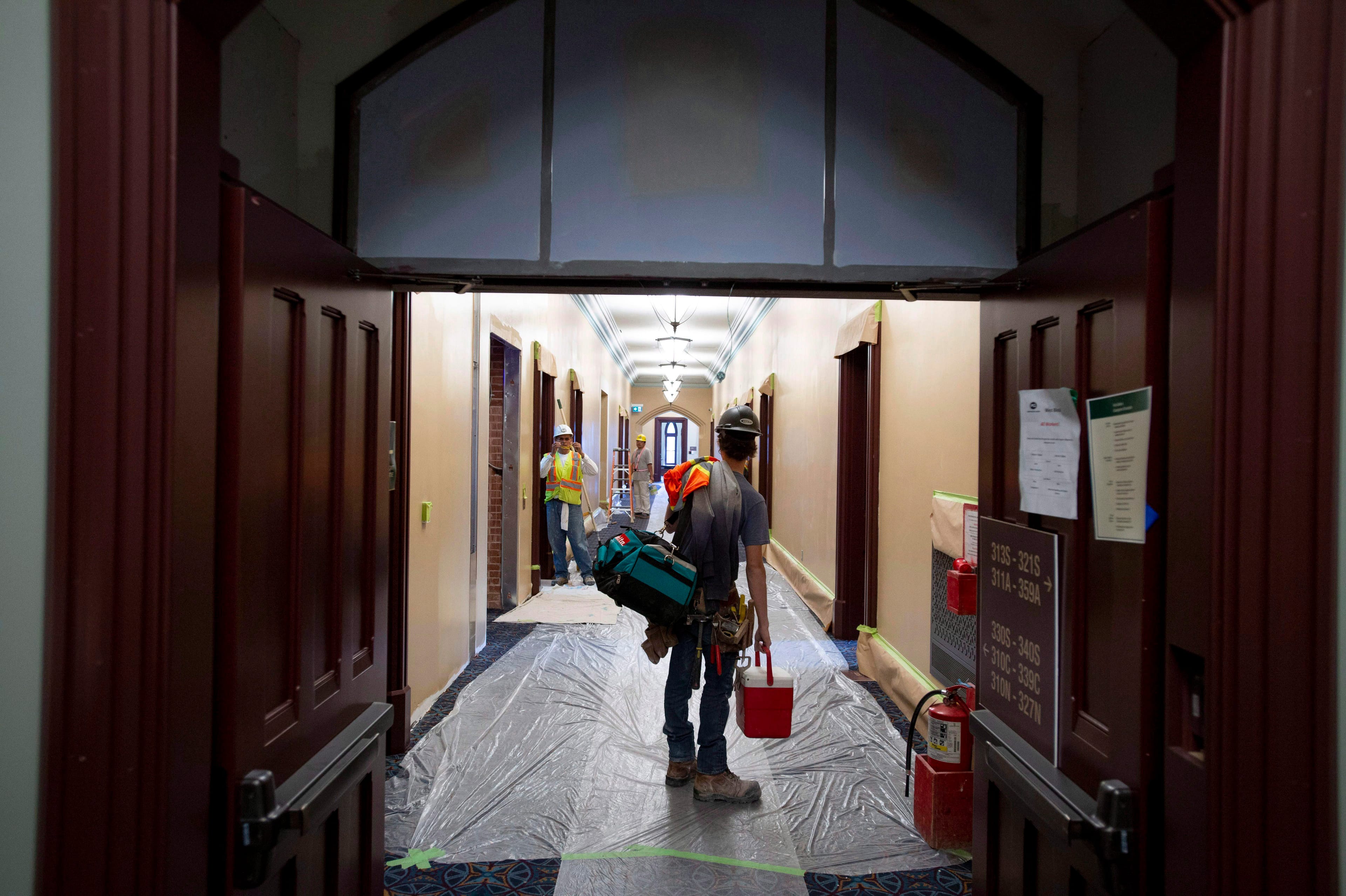 Workers painting a corridor of the renovated West Block on Parliament Hill in Ottawa on Friday, June 15, 2018. (Justin Tang/CP)