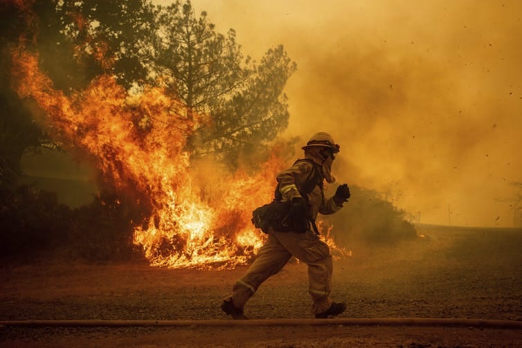 A firefighter runs while trying to save a home near Lakeport, Calif. on July 31, 2018.
(Noah Berger/File/AP)