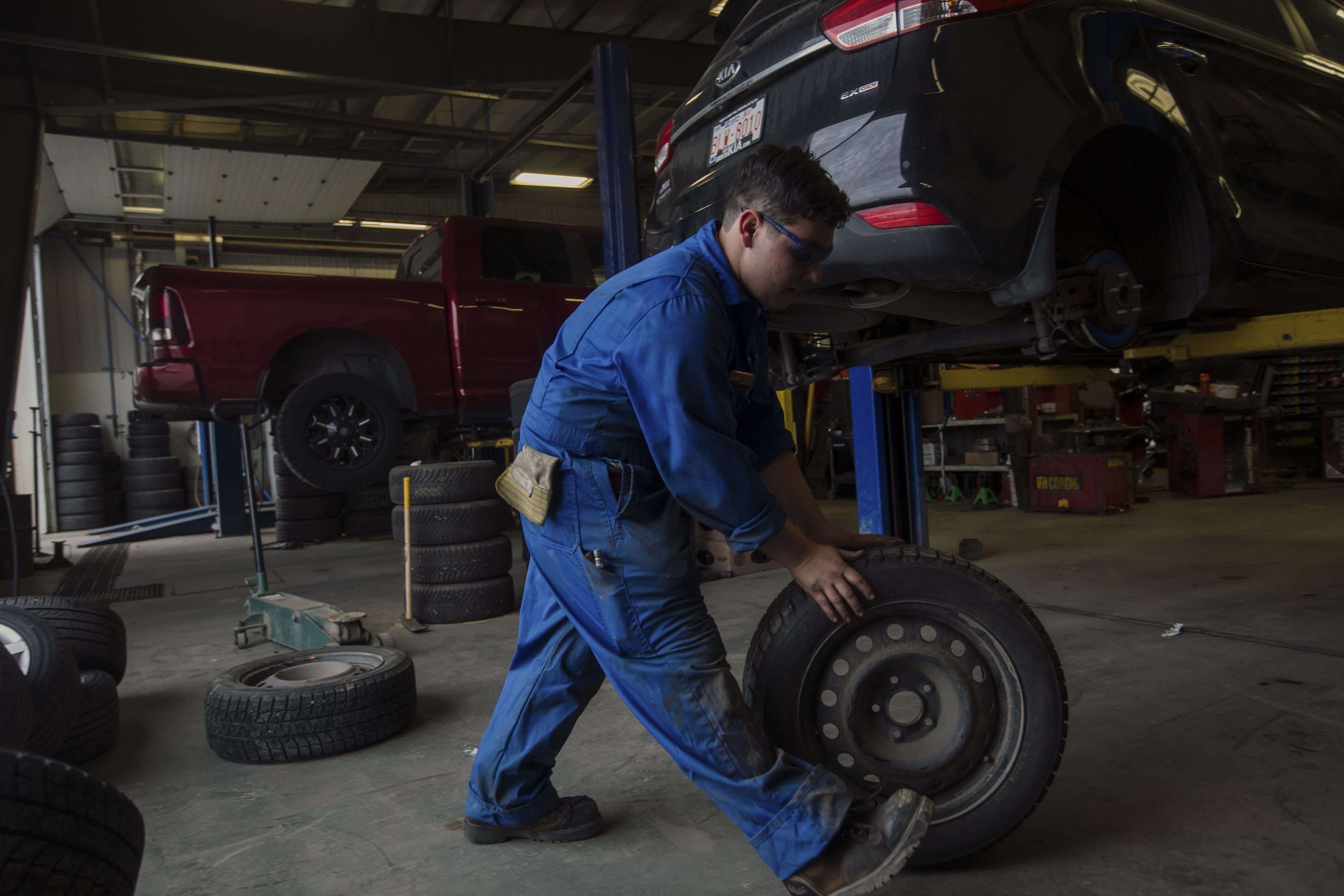 Tibi Gheorghe changes a set of tires on a customers vehicle at Fountain Tire in Edmonton on Oct. 30, 2018. (Amber Bracken)