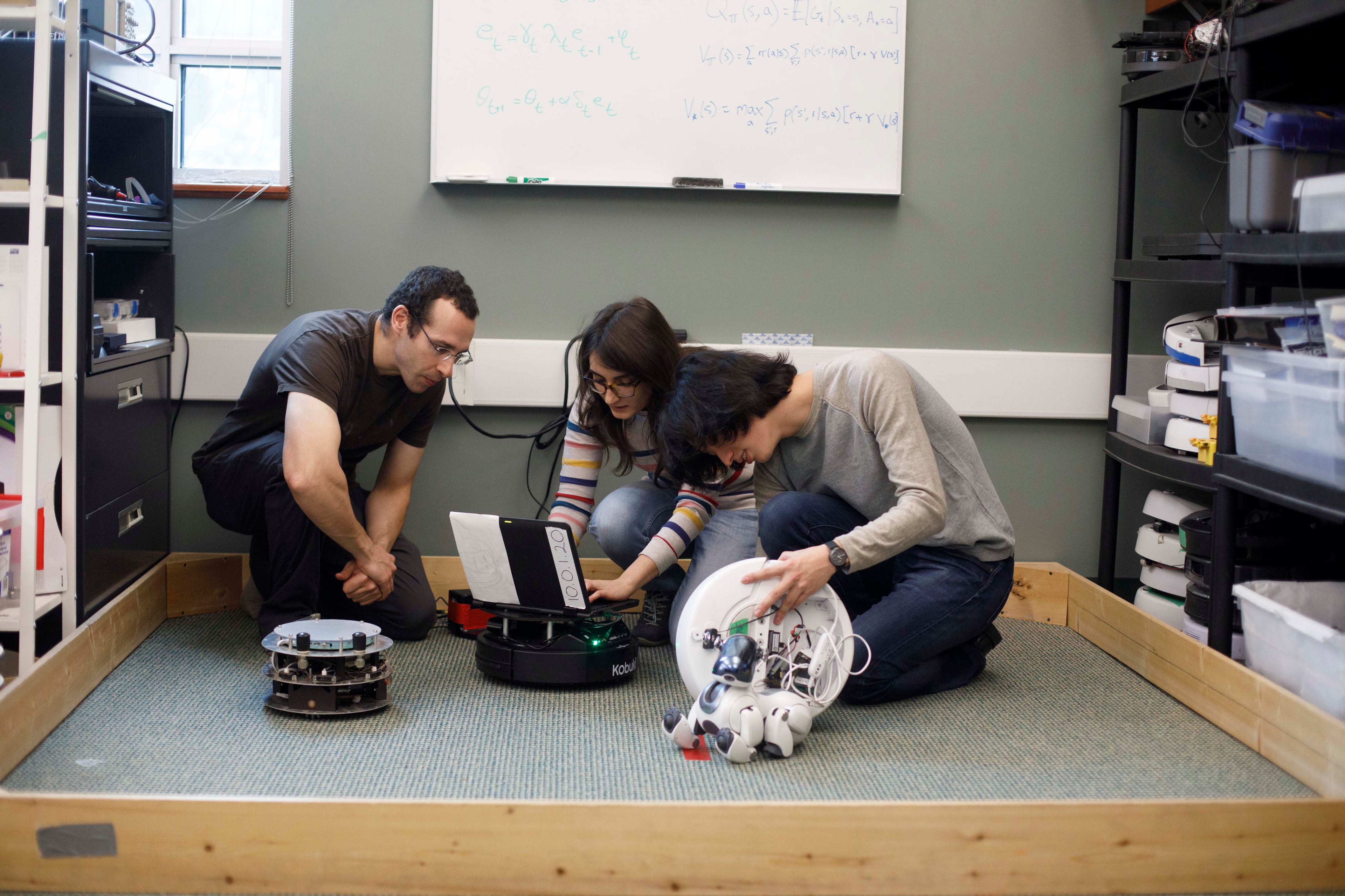 Computing science program, Adjunct Professor Adam White, left, MSC student Banafsheh Rafiee and MSC student Niko Yasui work on robots at the University of Alberta in Edmonton, Oct. 11, 2017. (Jason Franson)