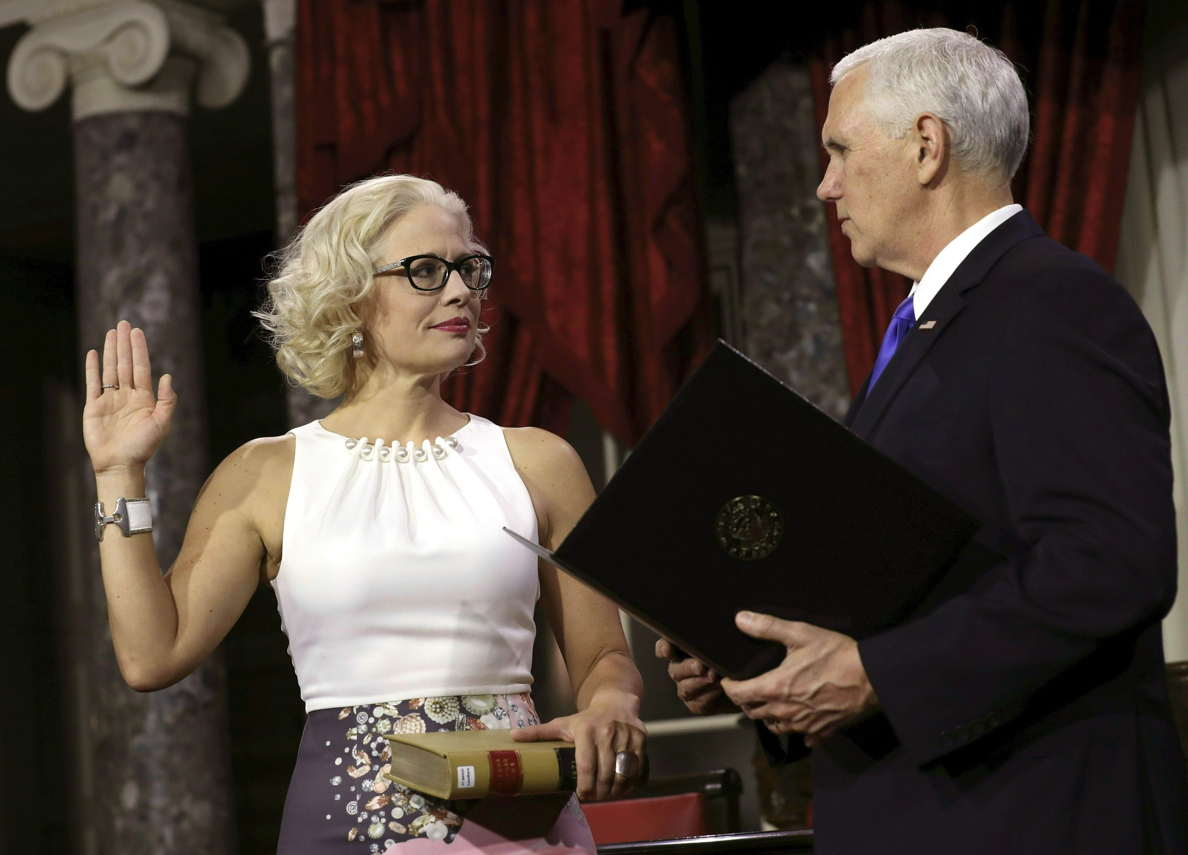 Sinema held a lawbook instead of a Bible as she was sworn in by Pence (Alex Edelman/AFP/Getty Images)